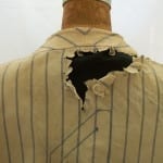 Large hole in the back of Lou Gehrig's jersey before conservation, mounted on a mannequin.