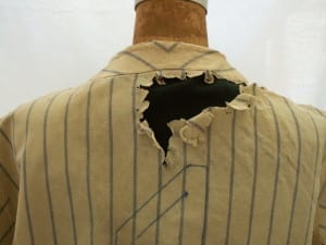 Large hole in the back of Lou Gehrig's jersey before conservation, mounted on a mannequin.