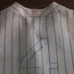 Upper back of Lou Gehrig's jersey showing fraying and the number 4 after conservation treatment.