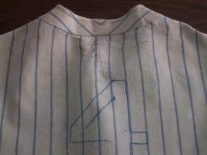 Upper back of Lou Gehrig's jersey showing fraying and the number 4 after conservation treatment.