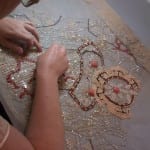 Conservator working on a beaded and sequined evening dress bodice.