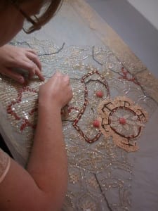 Conservator working on a beaded and sequined evening dress bodice.