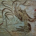 Post-conservation detail of the dragon motif on a pale blue net evening dress, showing the brown velvet and gold metallic thread appliqué re-stabilized and outlined with seed beads.