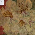 Post-conservation detail labeled "1" showing the previously heavily damaged needlework area now stabilized, with gold, tan, and rust floral motifs re-woven into the repaired zone.