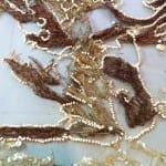 Frayed velvet dragon embroidery and displaced seed beads before conservation.