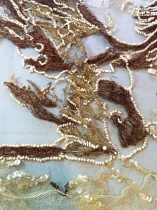 Frayed velvet dragon embroidery and displaced seed beads before conservation.