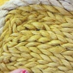 Close-up of thick golden-yellow braided fiber or rope forming a dense, textured surface.
