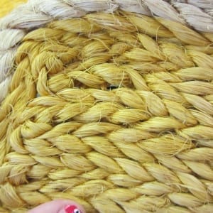 Close-up of thick golden-yellow braided fiber or rope forming a dense, textured surface.