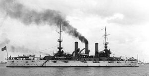 U.S. Battleship Vermont pictured on a cloudy day with billowing smoke stack.